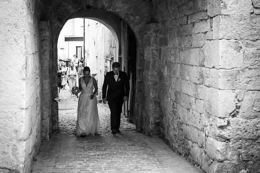 Das Hochzeitspaar auf dem Weg zur standesamtlichen Hochzeit. Das Foto ist in schwarz-weiß.