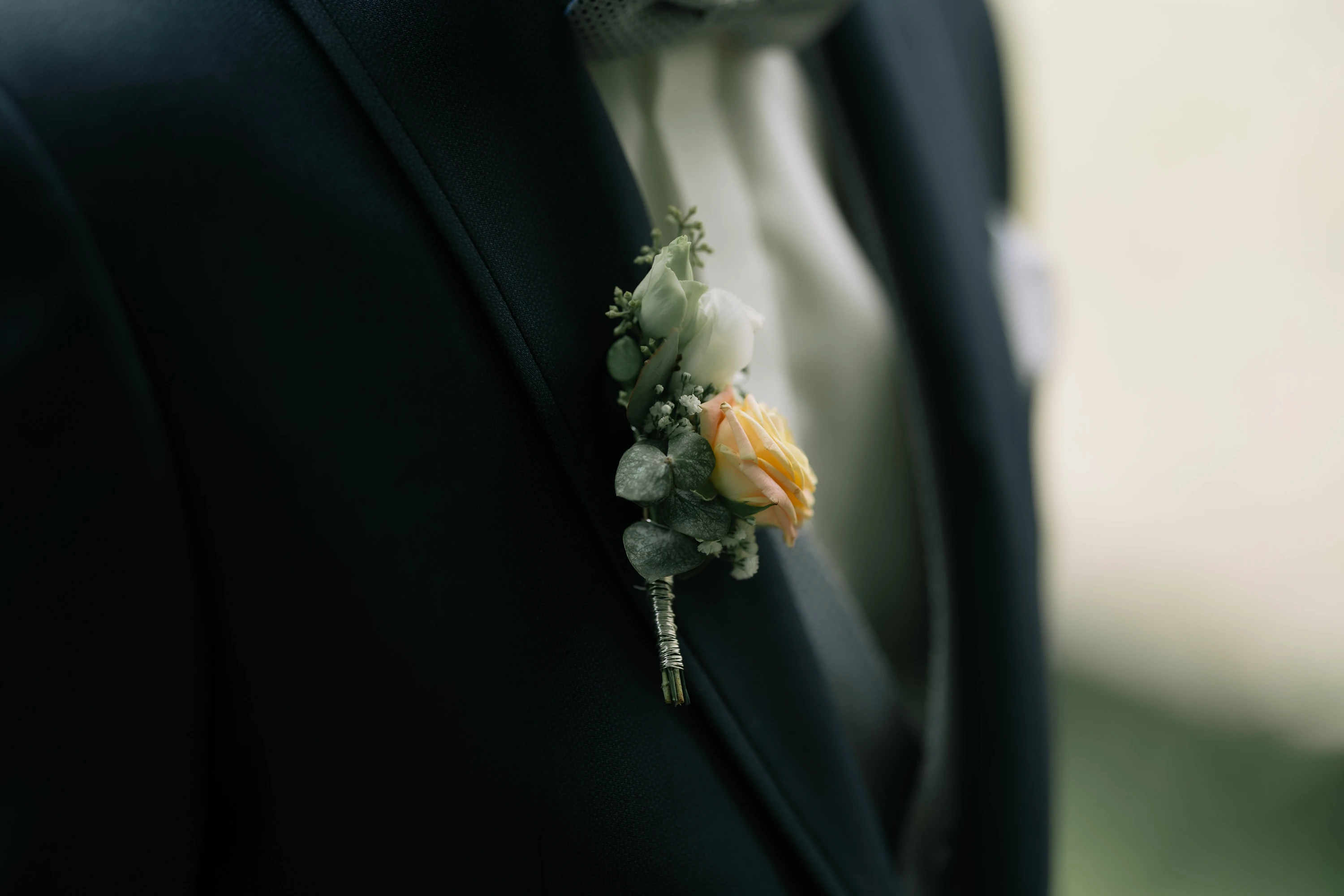 Blumenschmuck des Bräutigams, der an sein Revers befestigt ist.