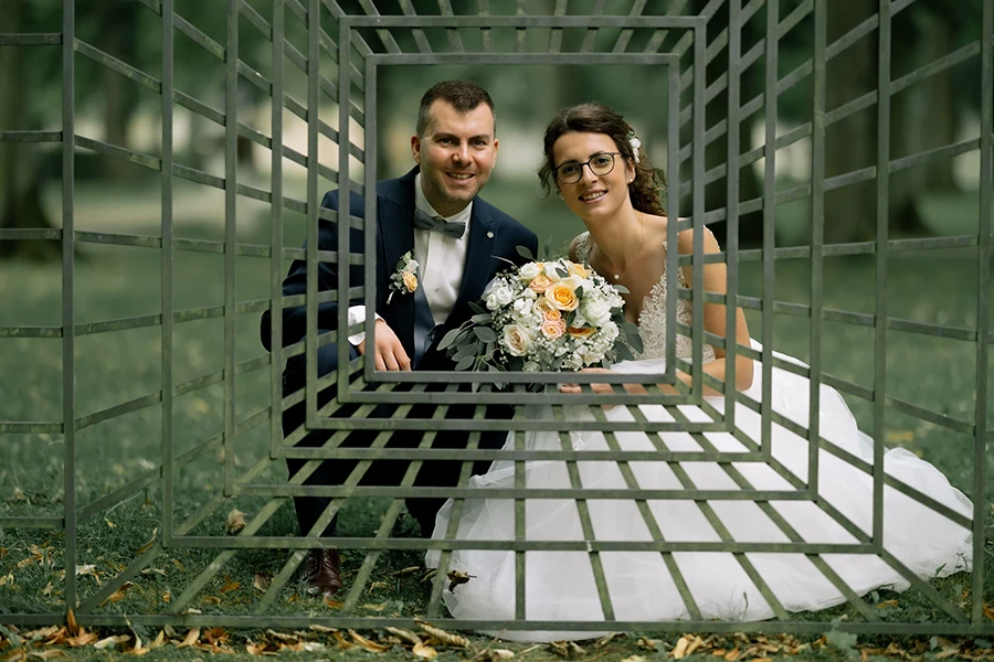 Das Brautpaar schaut durch ein gitter im Eichstätter Hofgarten.