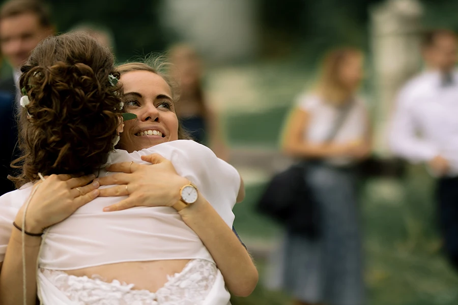 Eine Gästin umarmt die Braut und gratuliert ihr.