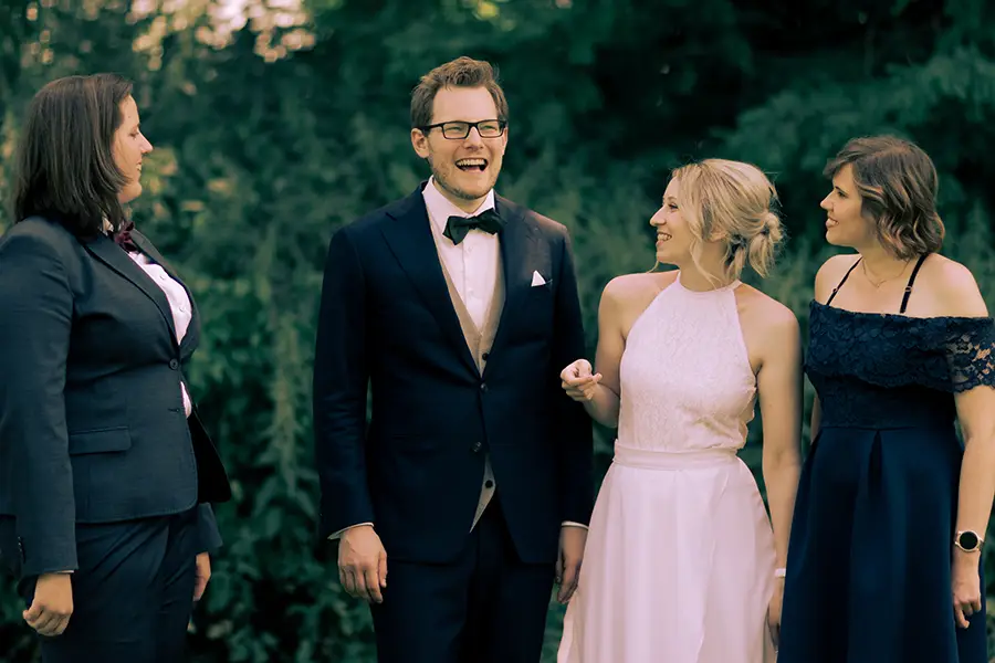 Das Brautpaar zusammen mit ihren Trauzeugen und lachen.