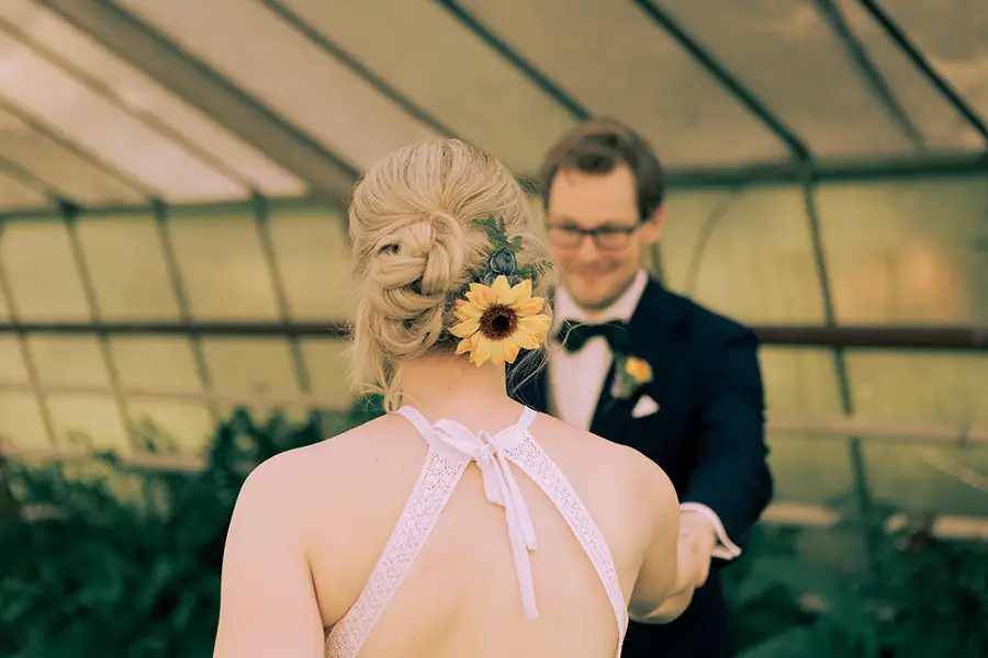 Das Brautpaar beim Tanzen, man sieht die Braut von hinten, wobei die Frisur und der Blumenschmuck im Haar scharf zu sehen sind.