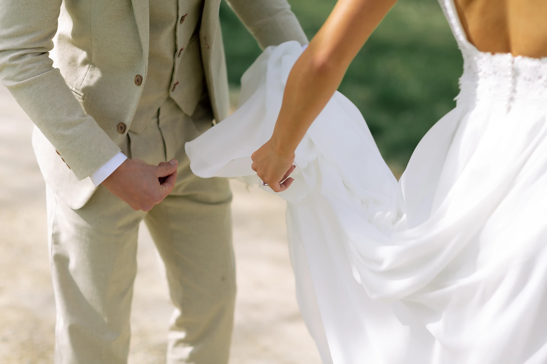 Der Bräutigam versucht das Brautkleid zu fixieren.
