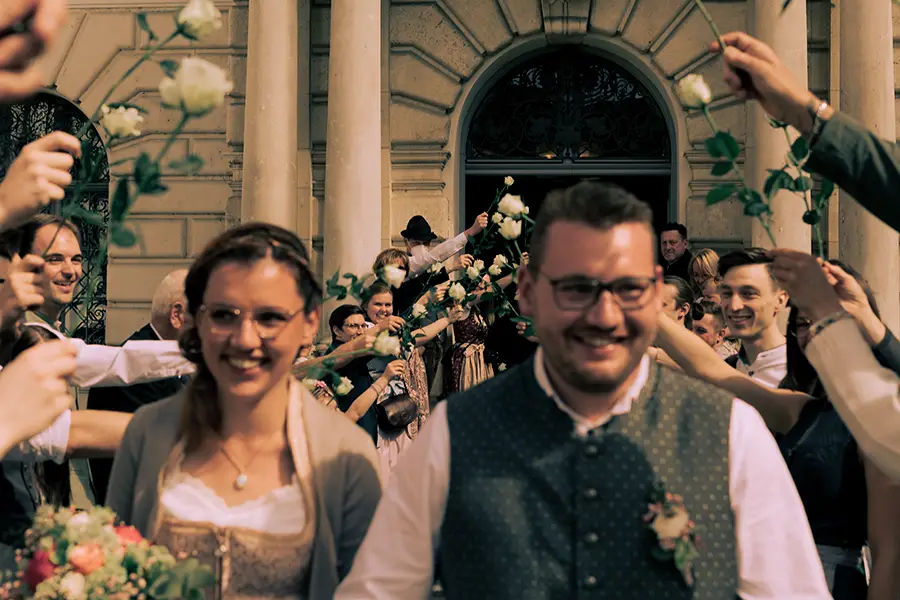 Foto wie die Gäste Spalier stehen, im Vordergrund ist unscharf das Brautpaar erkennbar.