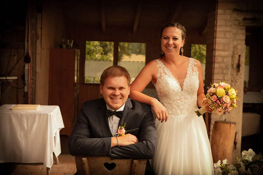 Ein Foto eine Hochzeitpaares, das in die Kamera lächelt.