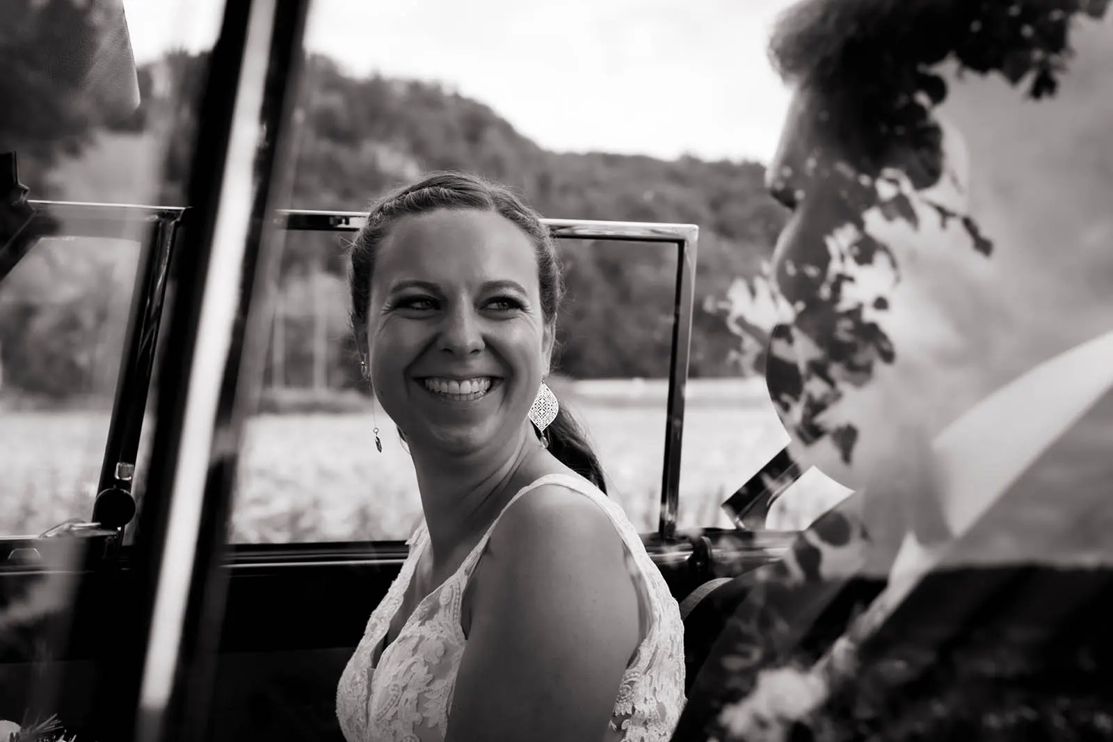 Ein schwarz-weiß Foto eines Hochzeitpaars im Auto
