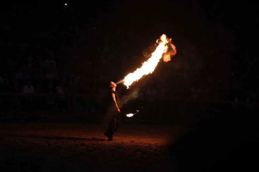 Ein Feuerspucker spuckt Feuer.