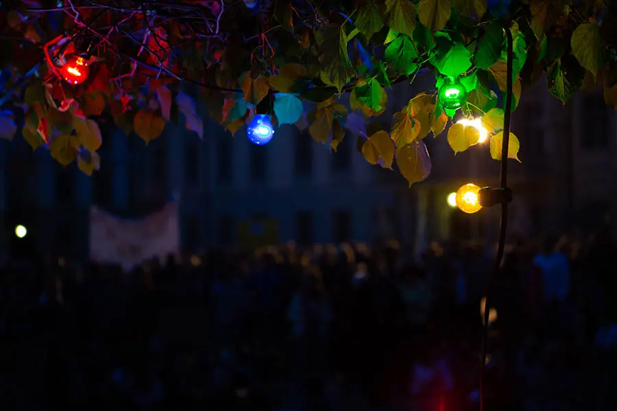 Nahaufnahme von bunten Glühbirnen, die in der Nacht in unterschiedlichen Farben leuchten.